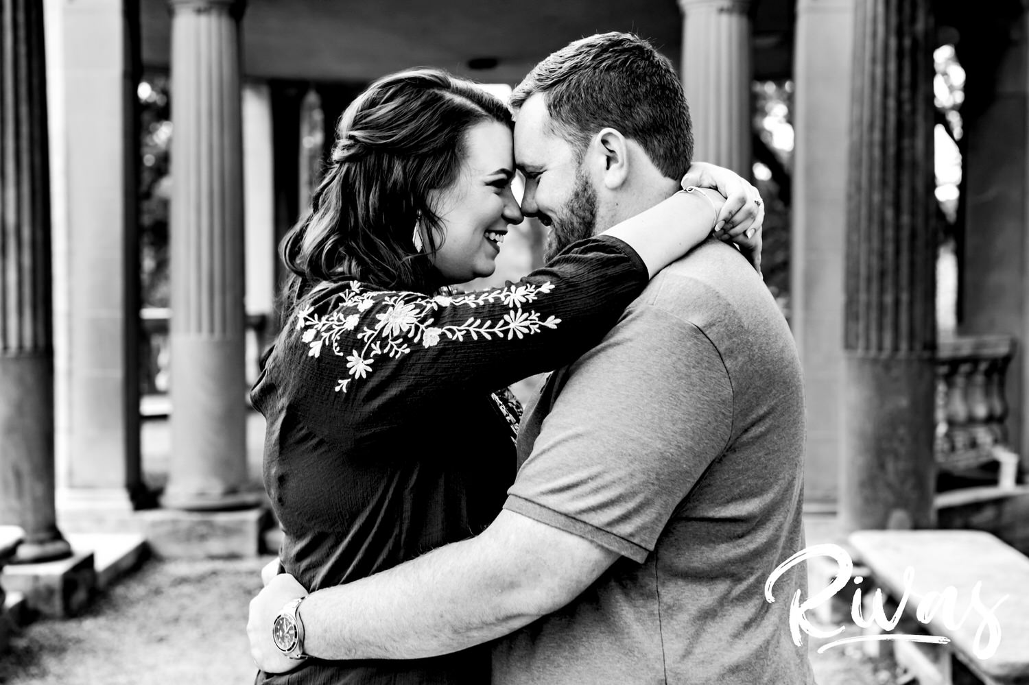 A black and white picture of an engaged couple sharing an intimate embrace during their engagement session in Kansas City. 