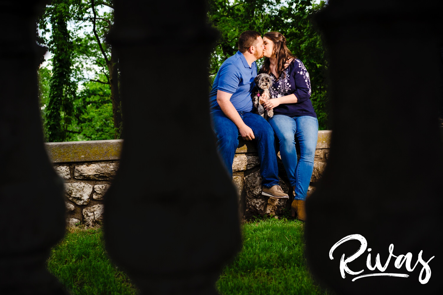 A candid picture of an engaged couple taken through a set of columns during their engagement session in Kansas City. 