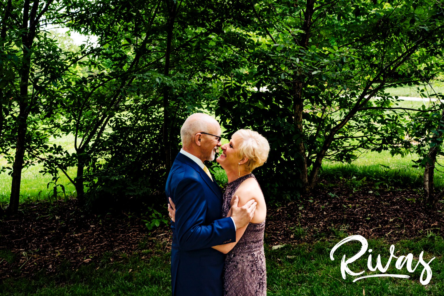 A colorful, candid picture of a bride and groom sharing their first look at the Omaha OPPD Arboretum. 