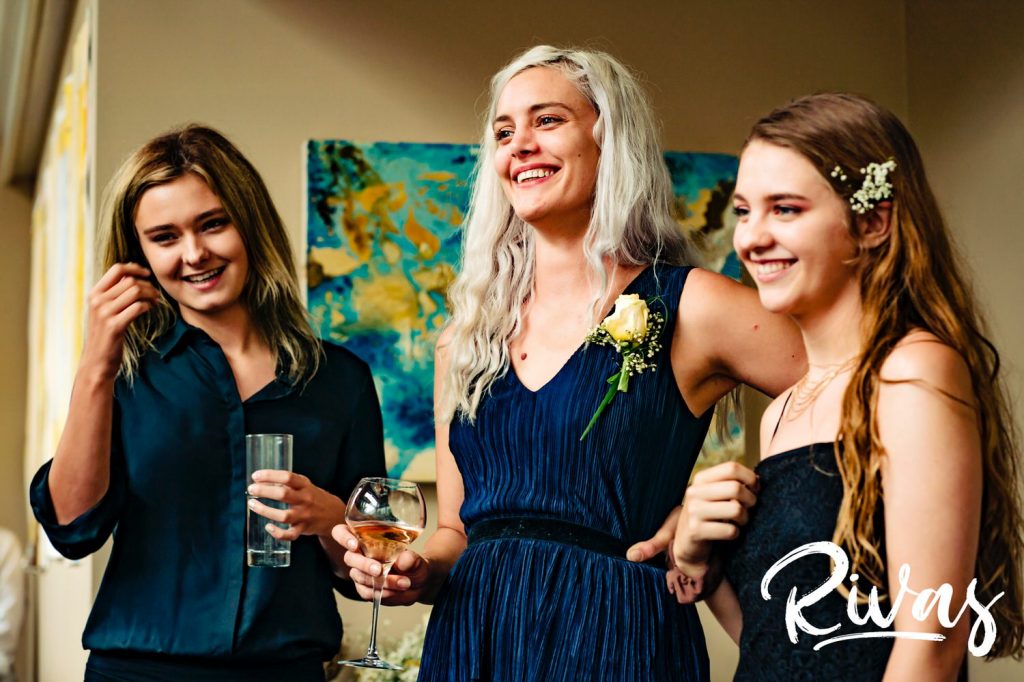 A candid picture of a groom's three adult daughters giving a toast during his celebratory wedding dinner at The Grey Plume in Omaha. 