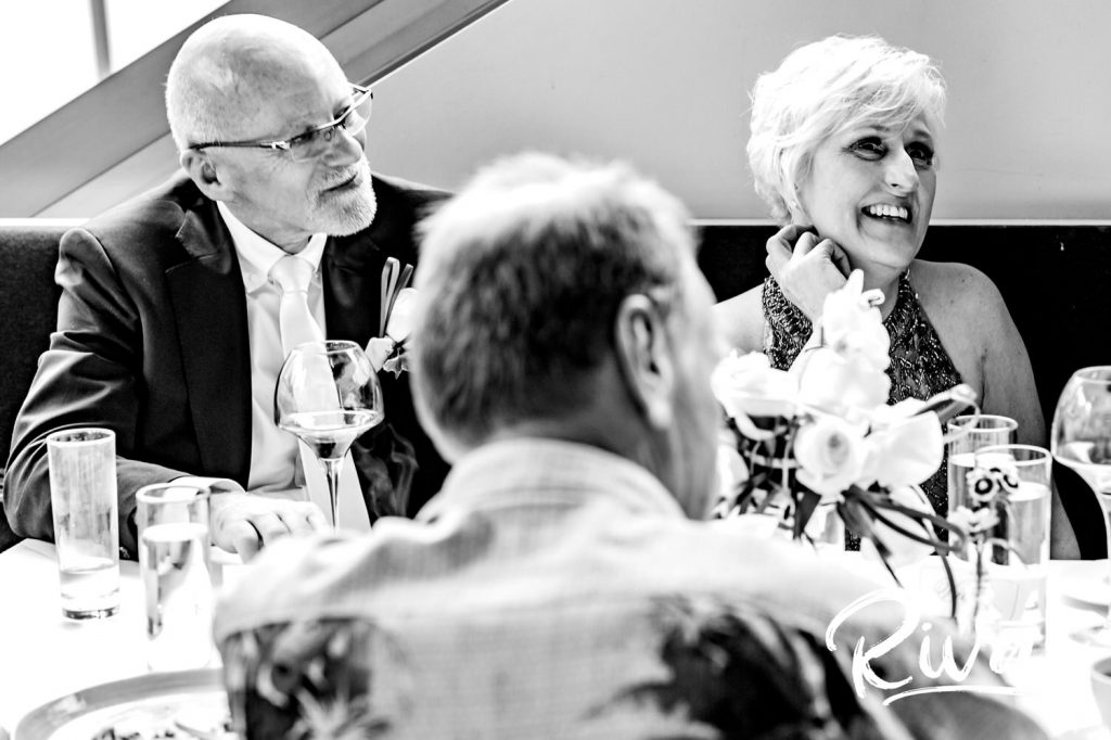 A sweet, black and white picture of a bride and groom listening to their children toast them during their celebratory dinner at Omaha's The Grey Plume. 