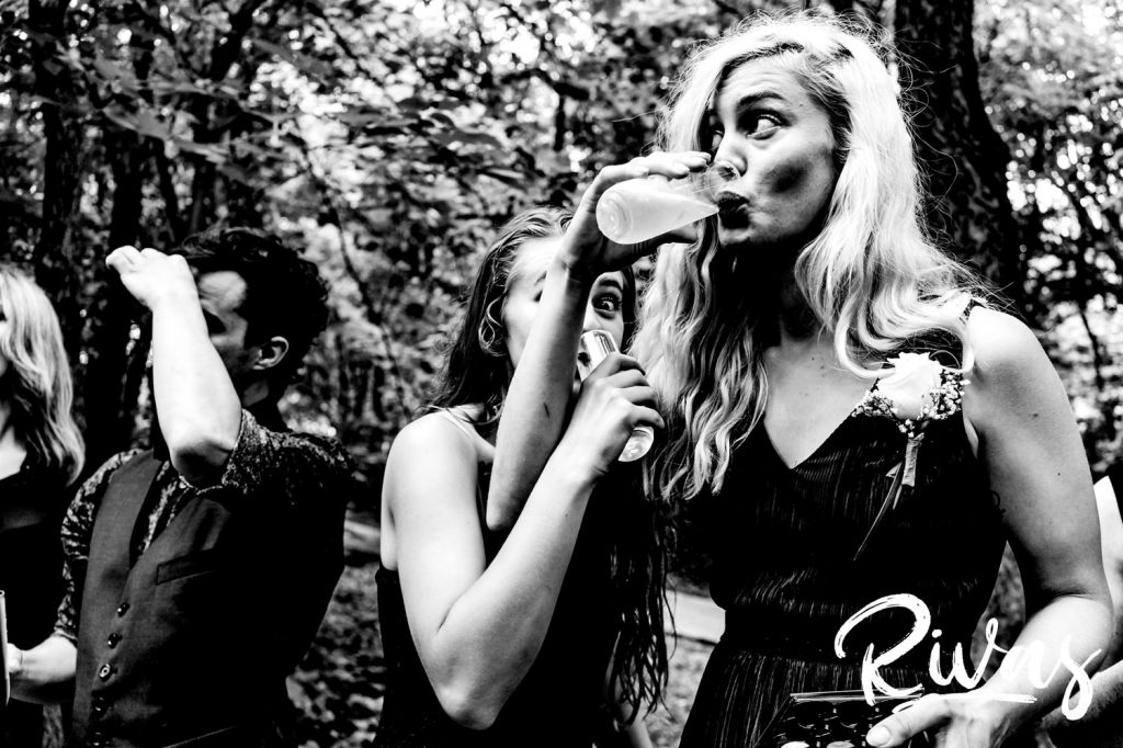 A silly, black and white picture of two sisters linking arms and drinking champagne to celebrate their parents' marriage. 