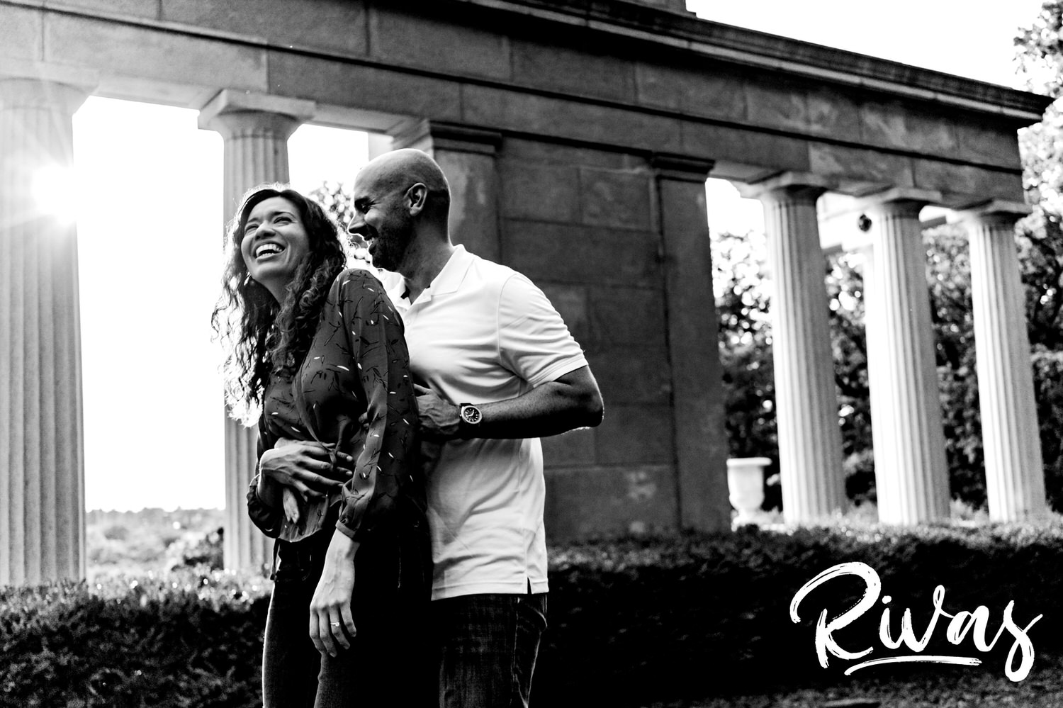 A candid black and white picture of a man tickling his fiance during their engagement session at Swope Park in Kansas City. 