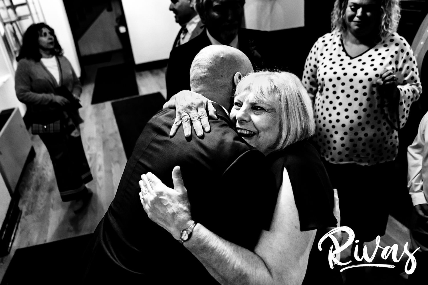 A candid black and white picture of a groom hugging his mom just after his wedding ceremony in Kansas City. 