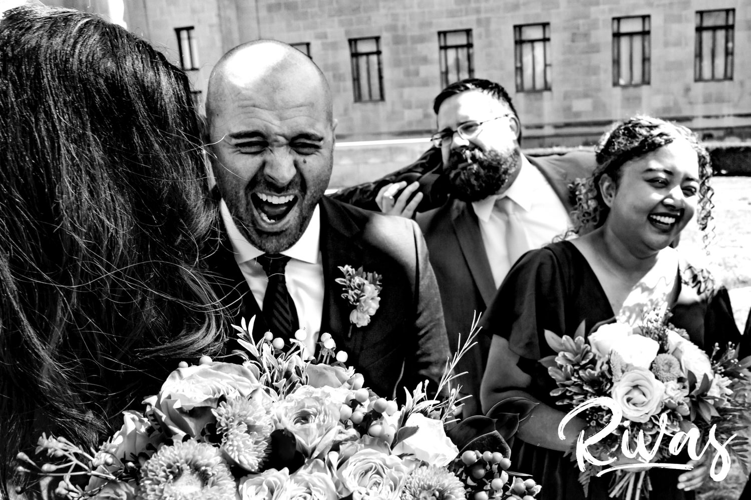 A tight, candid picture of a bride and groom laughing hysterically on their wedding day with their best man and maid of honor at The Nelson Atkins Museum of Art on the day of their Kansas City wedding. 