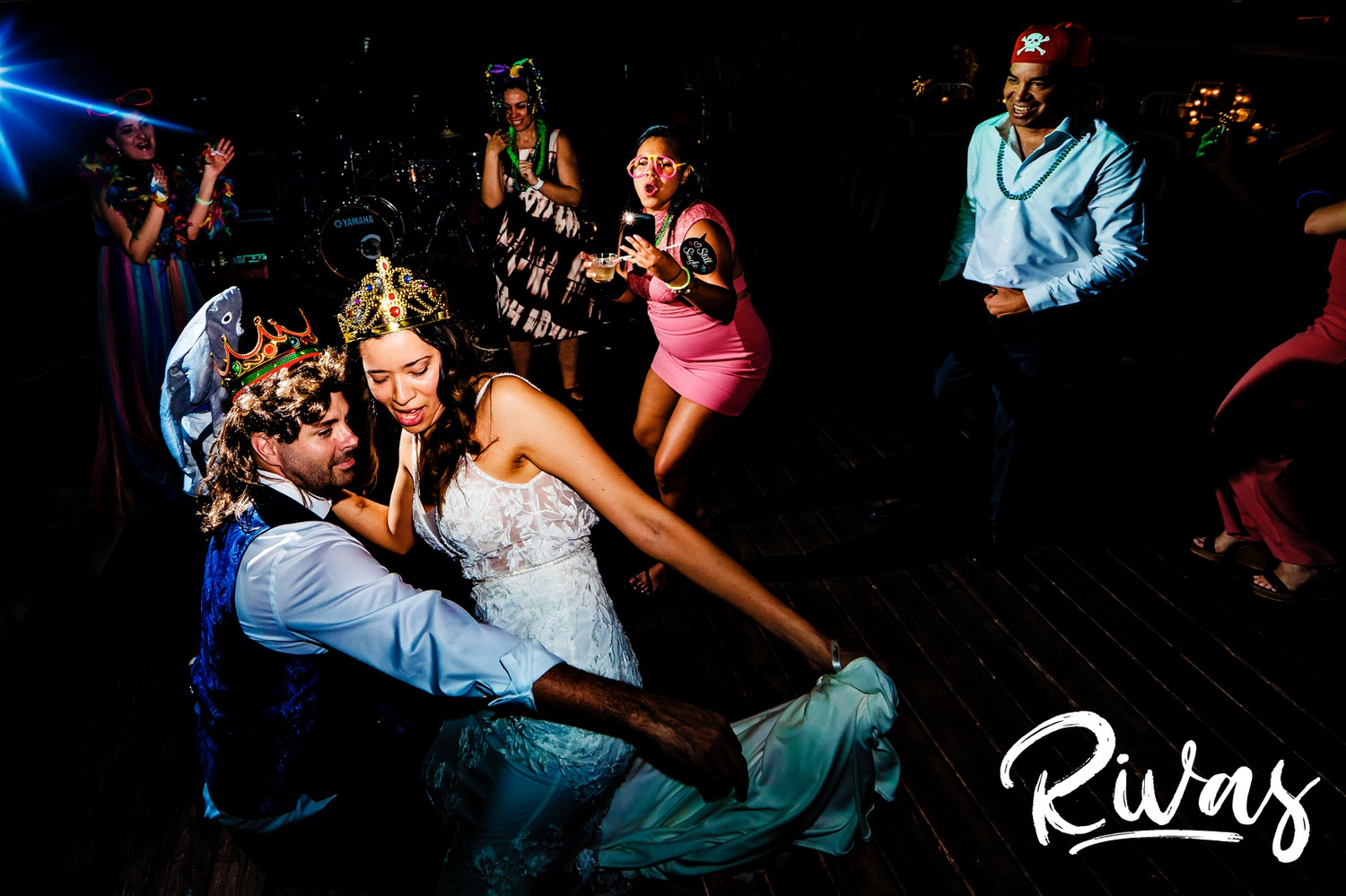 A candid picture of a bride and groom, both in crowns, sharing a dance during their wedding reception in Kansas City. 