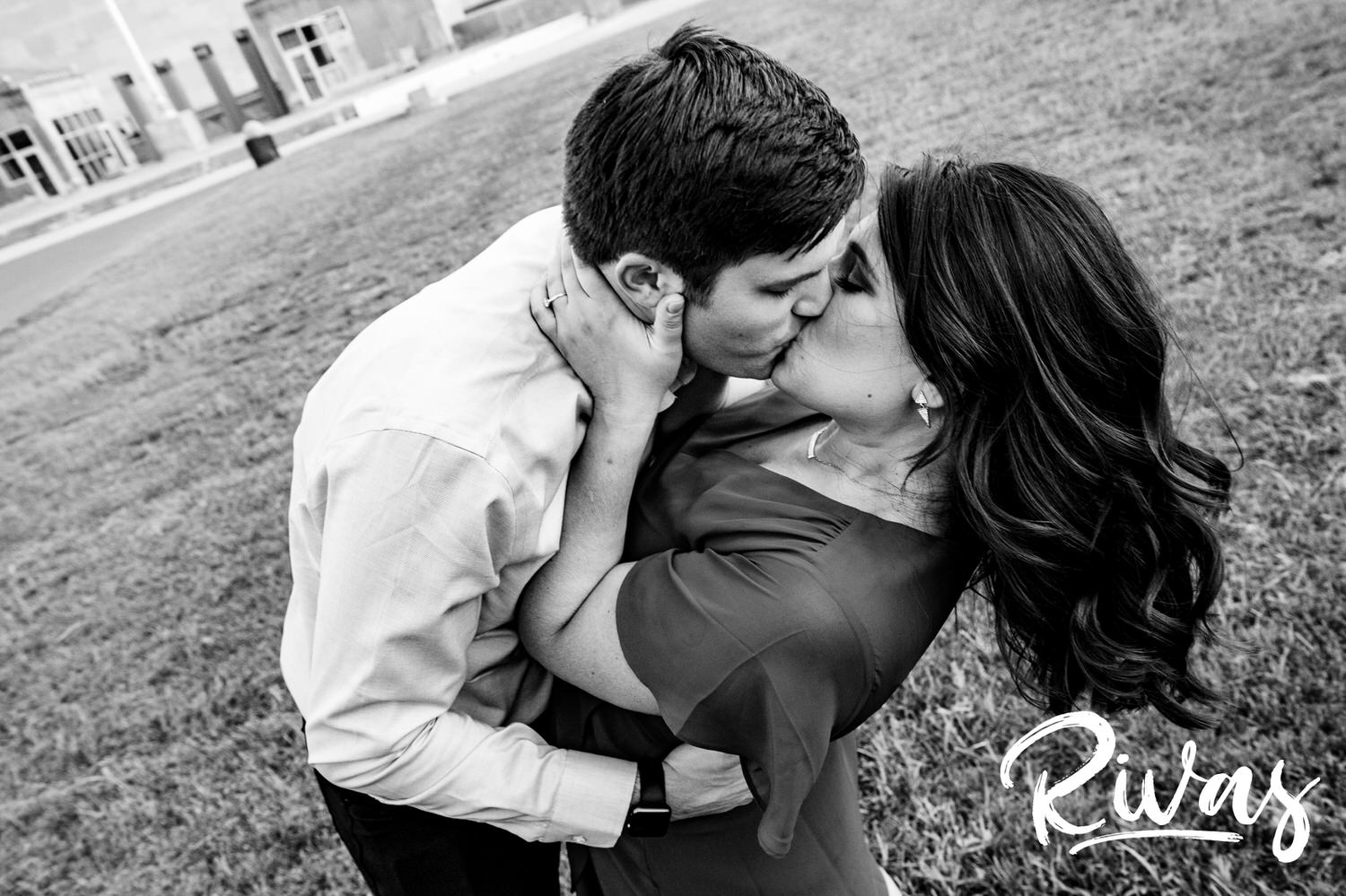 A candid black and white picture of an engaged couple sharing a romantic kiss during their fall engagement session in downtown Kansas City. 