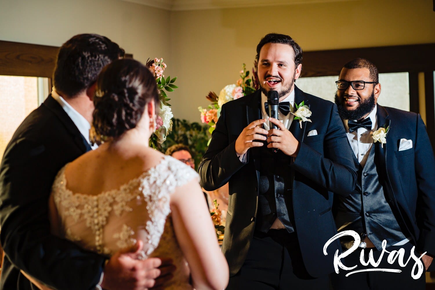 A candid picture taken from behind the bride and groom of two best men giving a toast during a wedding reception at Lawrence Country Club on a summer wedding day. 