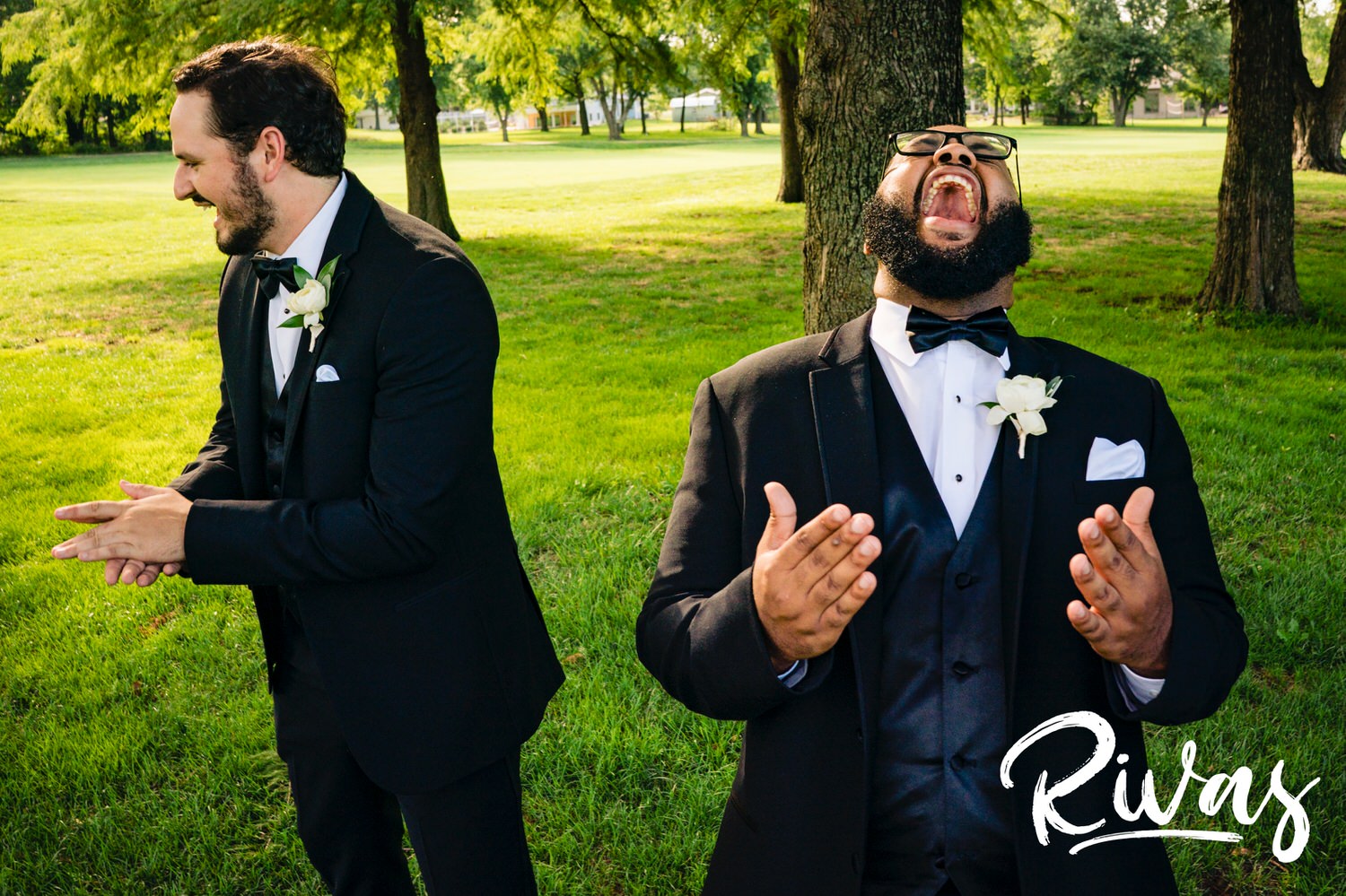 A candid black and white picture of a groomsman holding his eyes and laughing hysterically during wedding party pictures at Lawrence Country Club on a summer wedding day. 