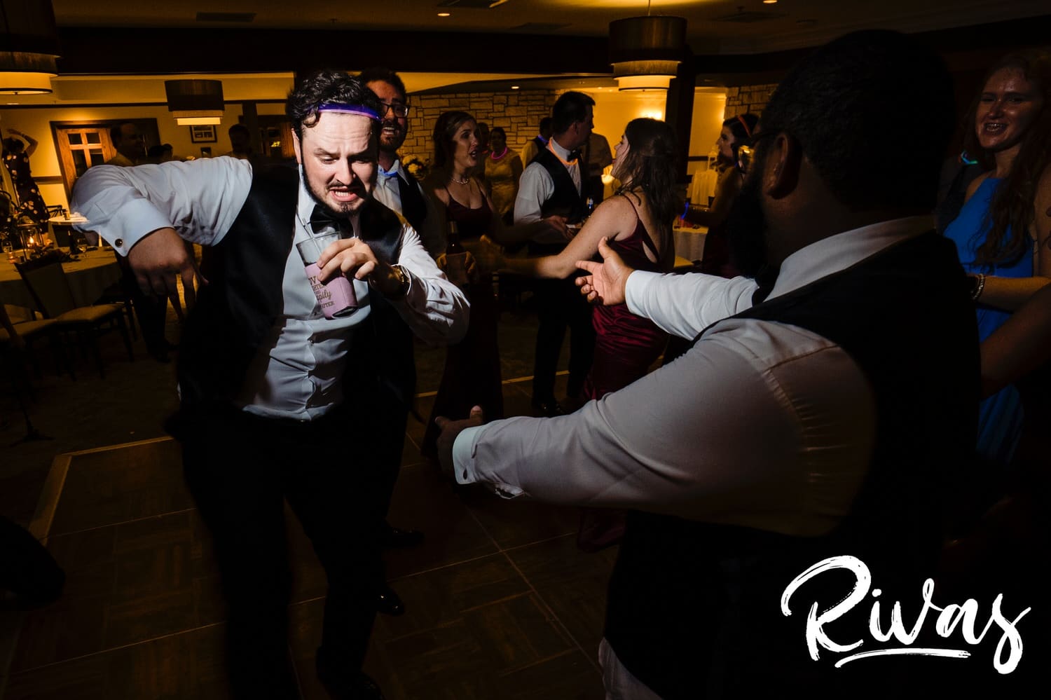 A candid picture of two groomsmen dancing enthusiastically during a summer wedding reception at Lawrence Country Club. 