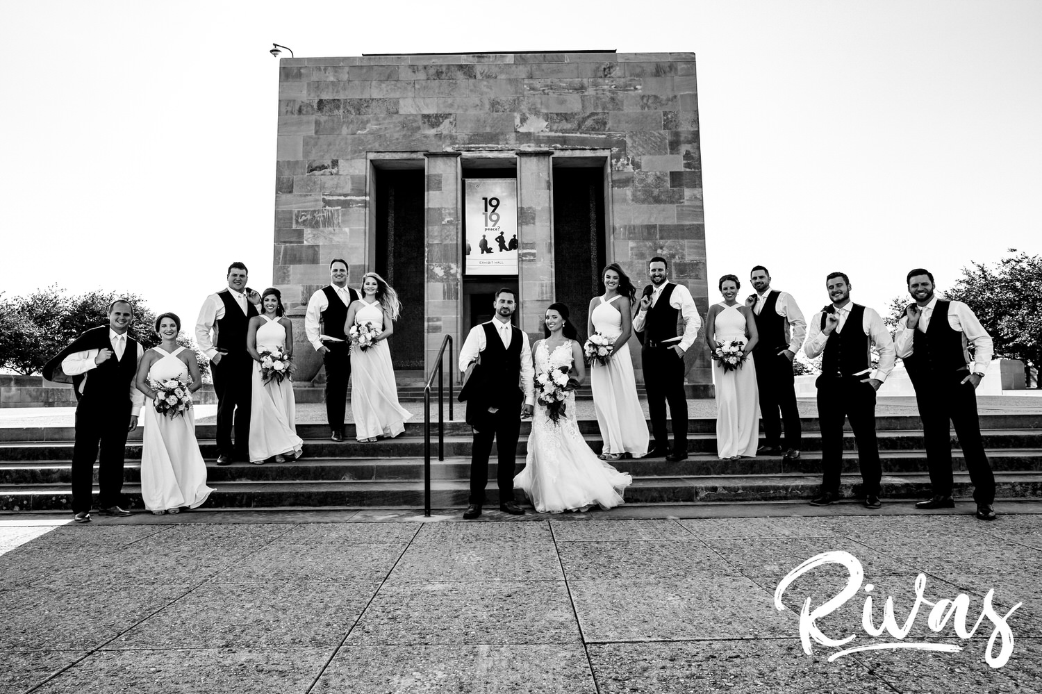 A candid black and white picture of a wedding party smiling at the camera on a wedding day in downtown Kansas City. 