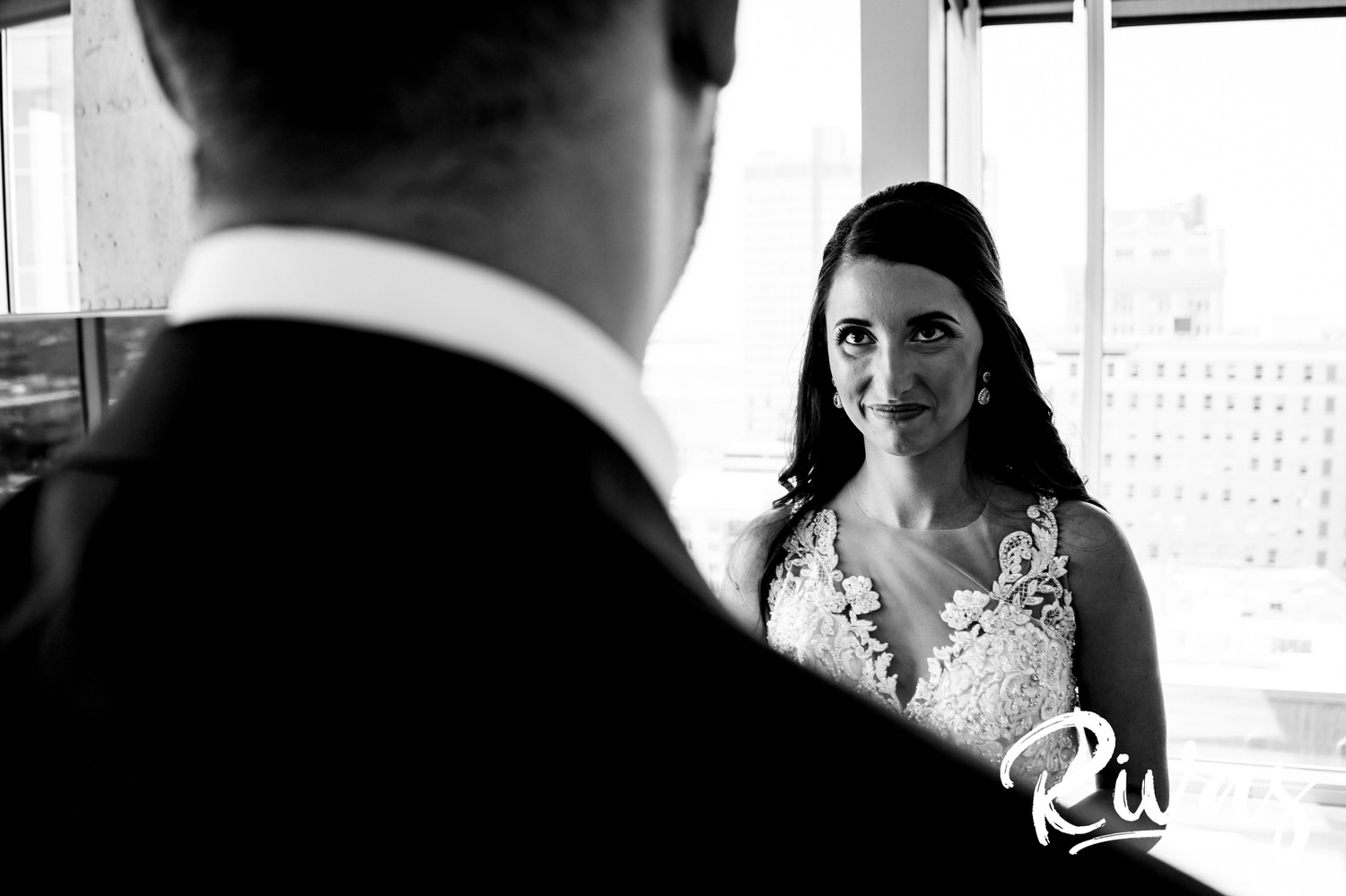 A candid black and white picture of a bride looking lovingly up at her groom on her wedding day. 