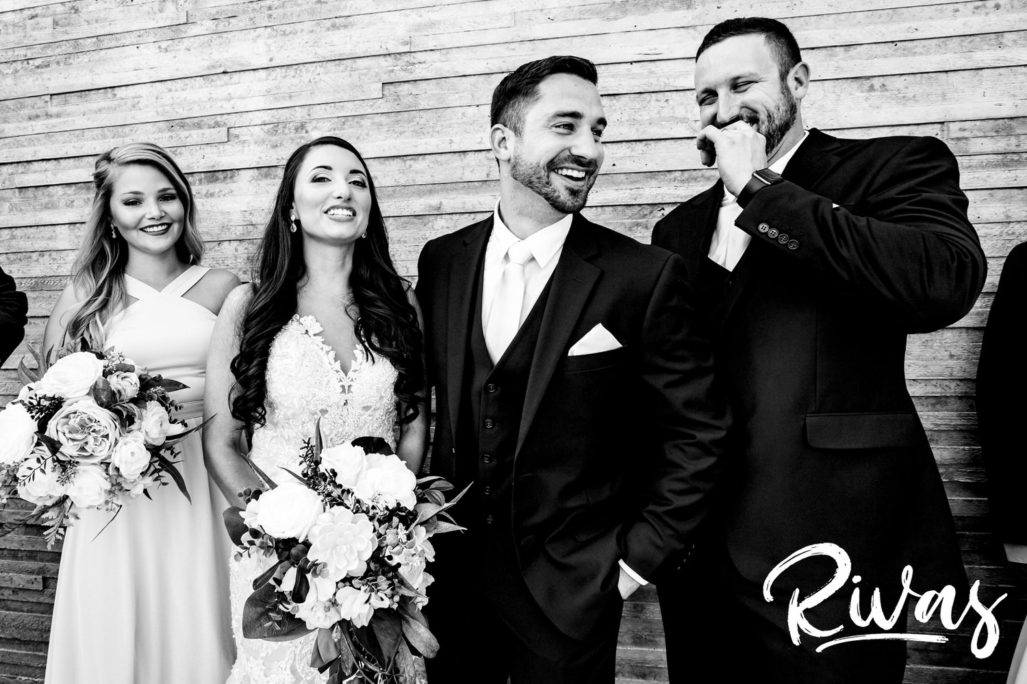 A candid black and white picture of a bridesmaid and groomsman laughing on a Kansas City wedding day. 