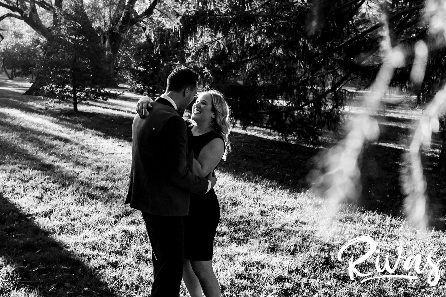 A candid black and white picture of a woman looking adoringly up at a man during their fall engagement session at Loose Park in Kansas City. 