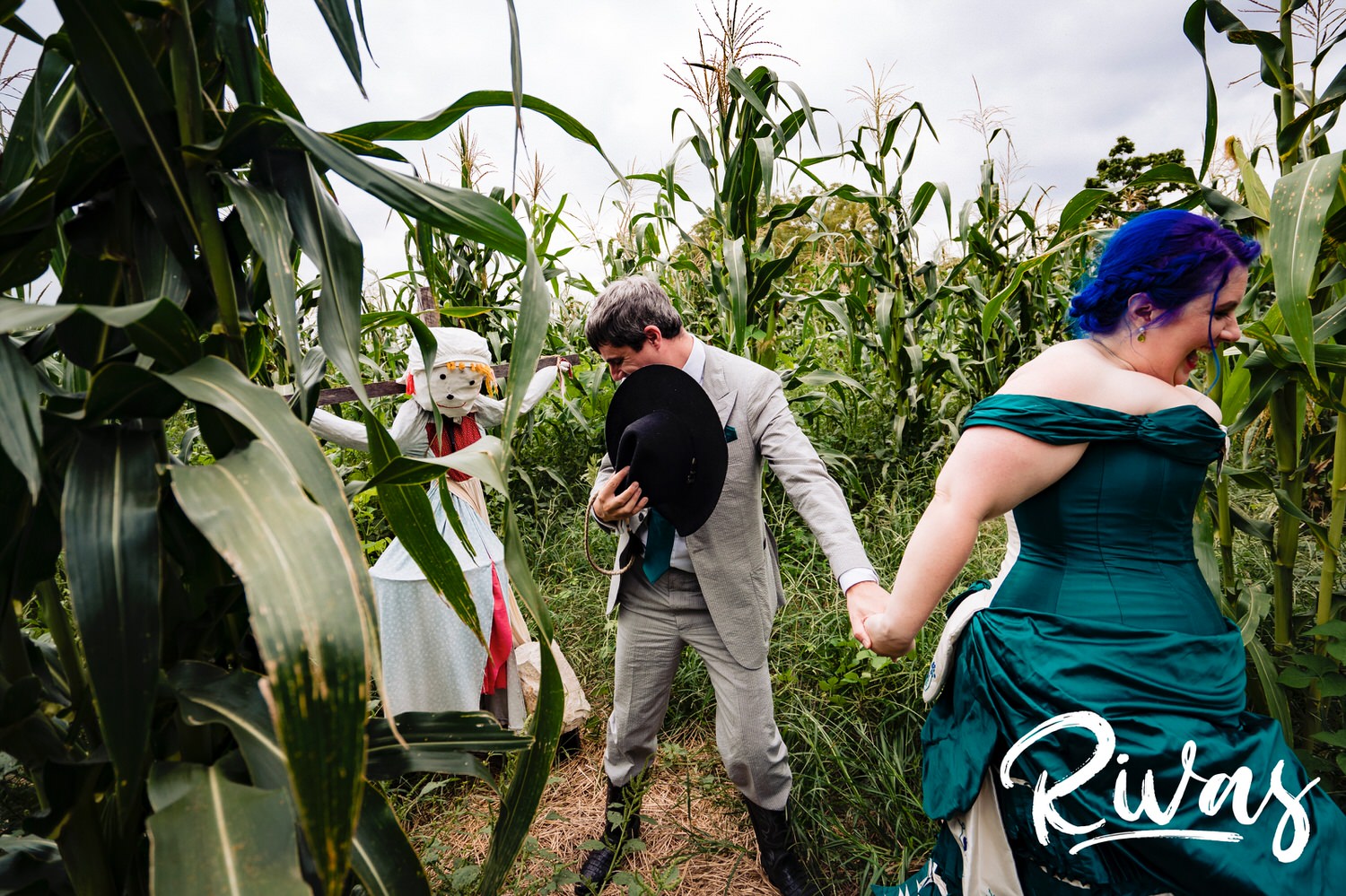 A candid picture of a bride and groom running through a cornfield on their wedding day. 