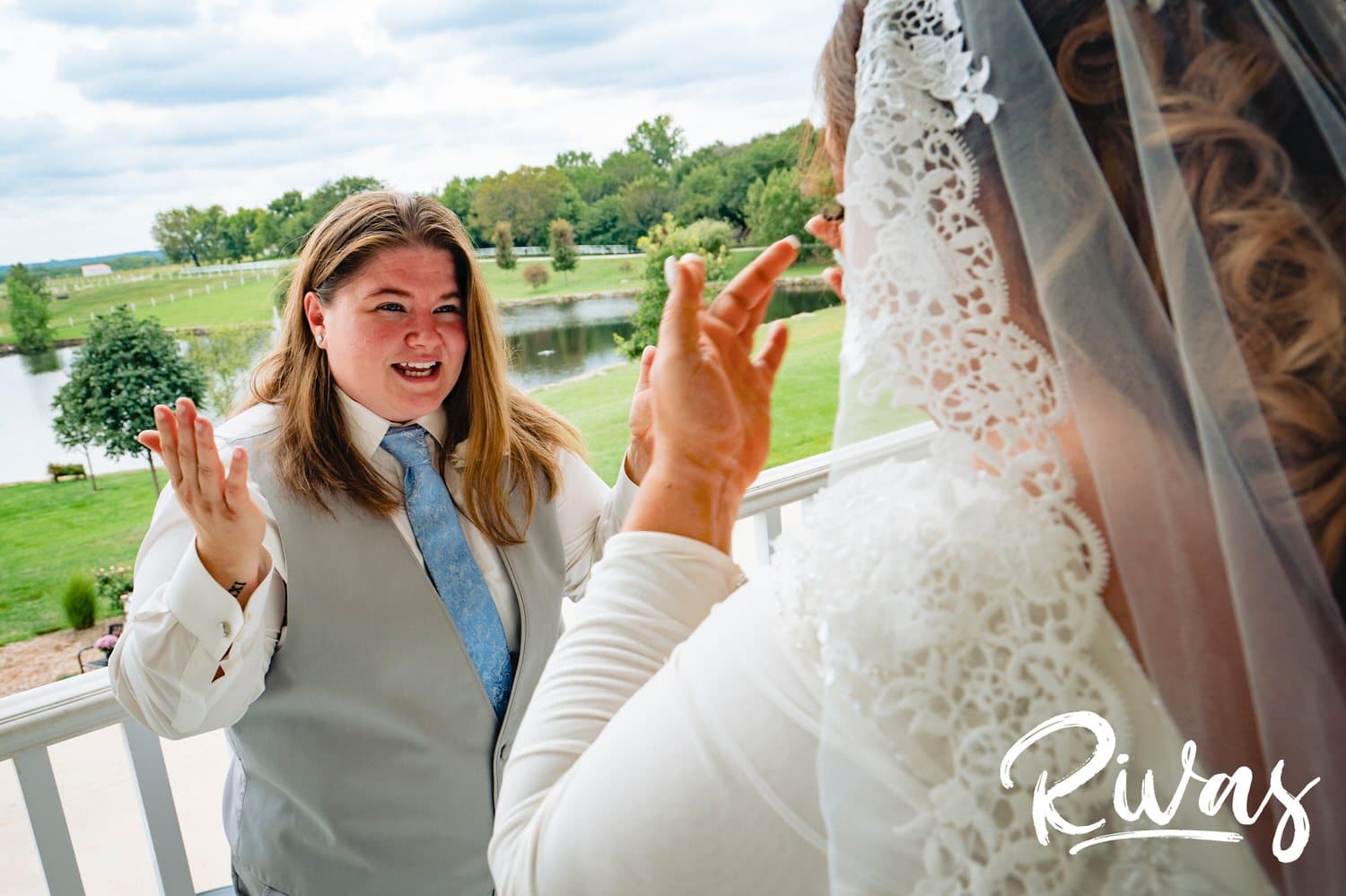 A candid picture of two brides reacting to seeing each other for the first time on their wedding day at Fire Stables. 