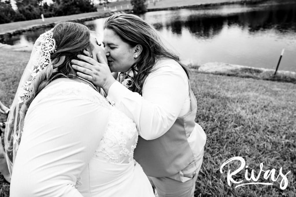An up-close, intimate picture of two brides leaning in to share a kiss on their wedding day at Fire Stables. 