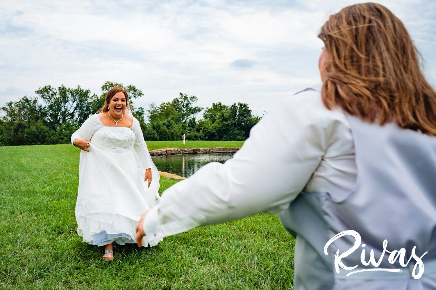 A candid, colorful picture of two brides running towards each other in celebration on their wedding day at Fire Stables. 
