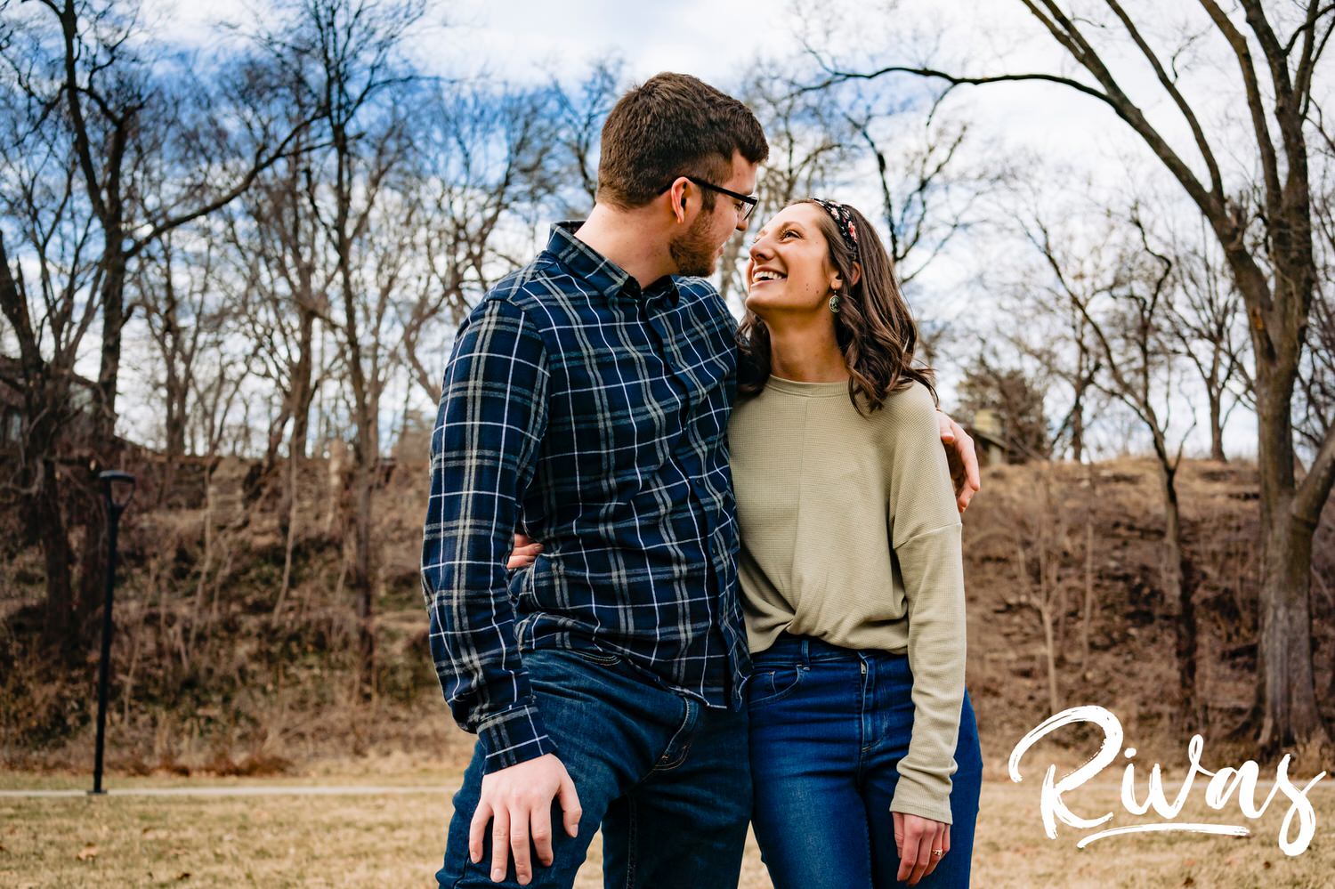 A colorful, candid picture of an engaged couple sharing an embrace during their winter engagement session. 