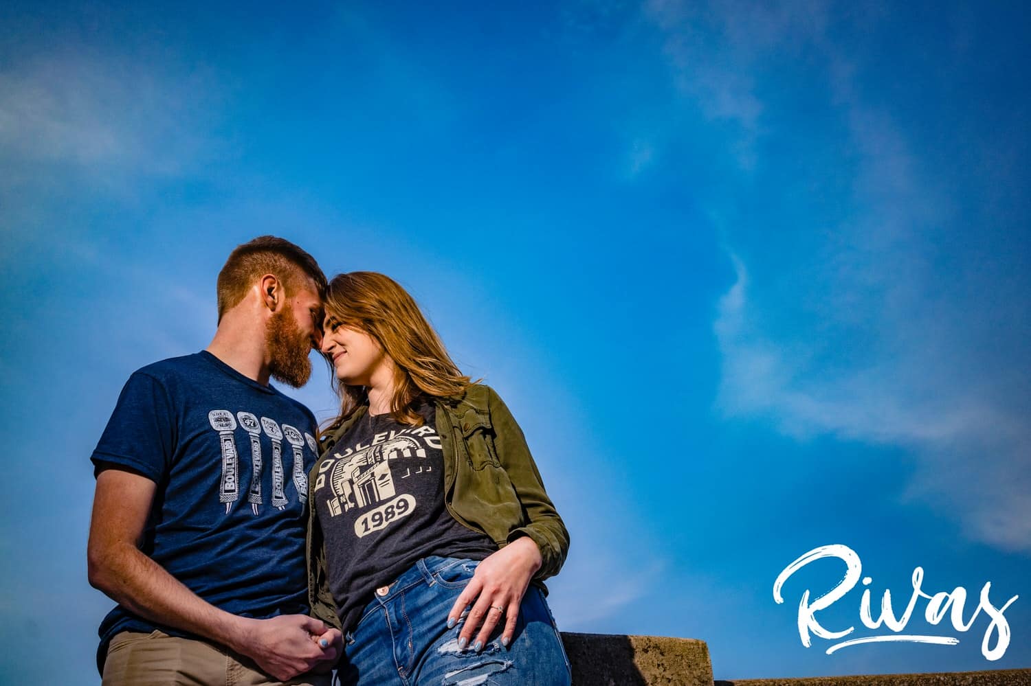 A colorful, candid picture of an engaged couple leaning forehead to forehead during their downtown Kansas City engagement session. 