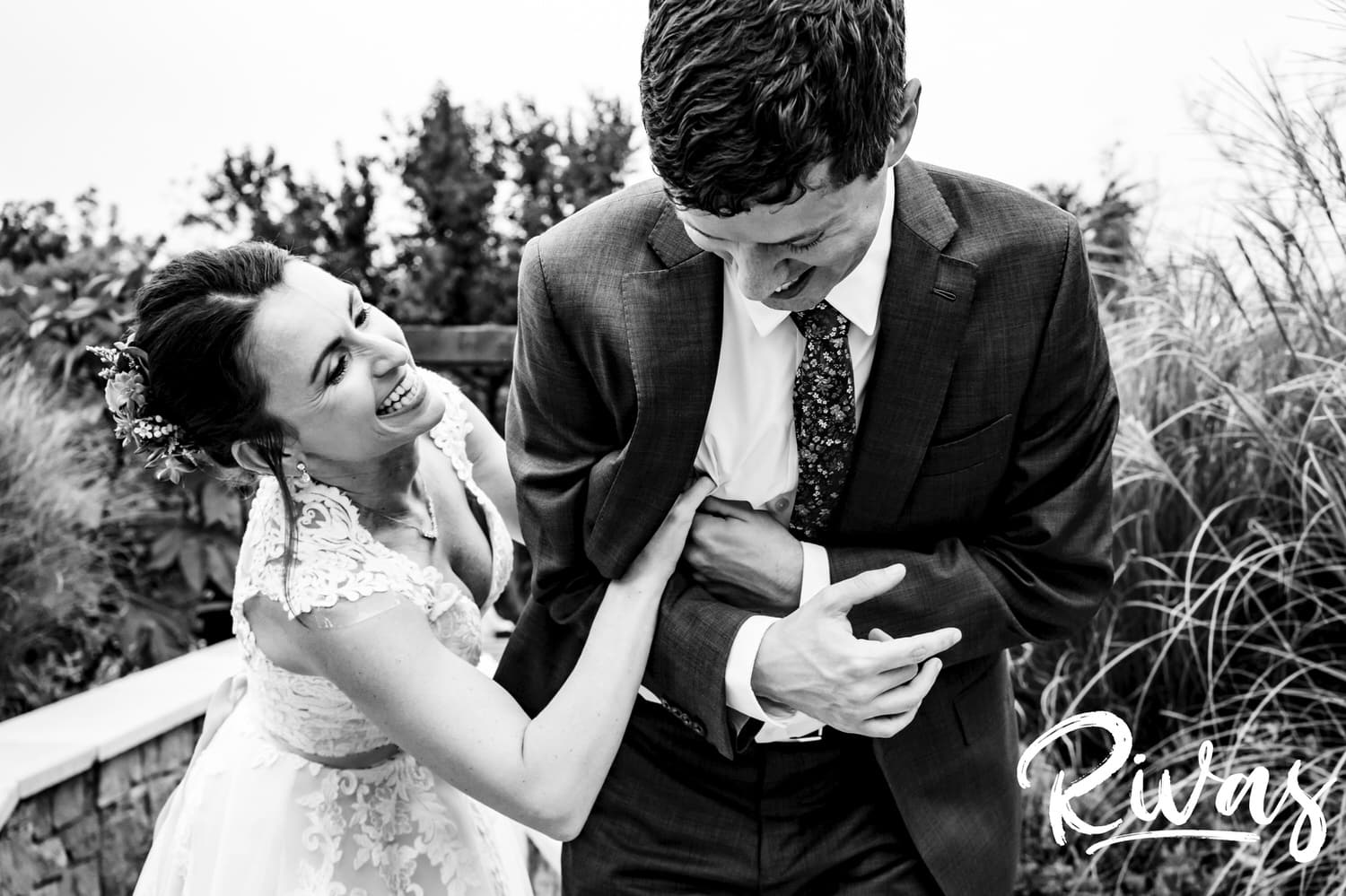 A silly, candid, black and white picture of a bride tickling her groom on their wedding day. 