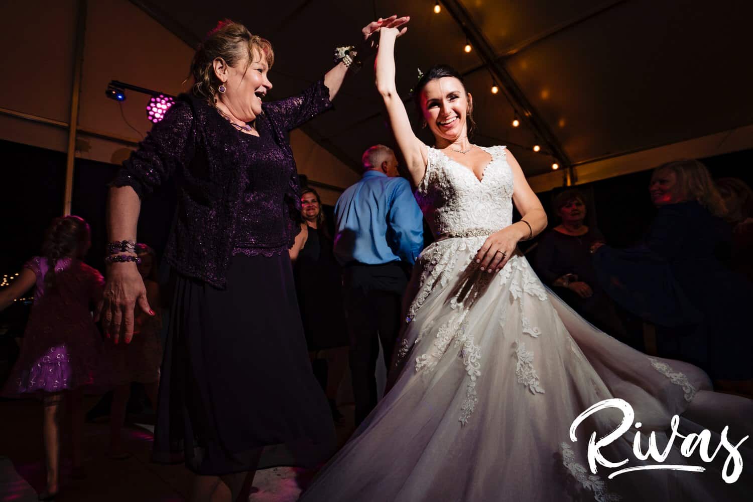A candid picture of a bride's mom twirling her under her arm during a wedding reception at The Bowery. 