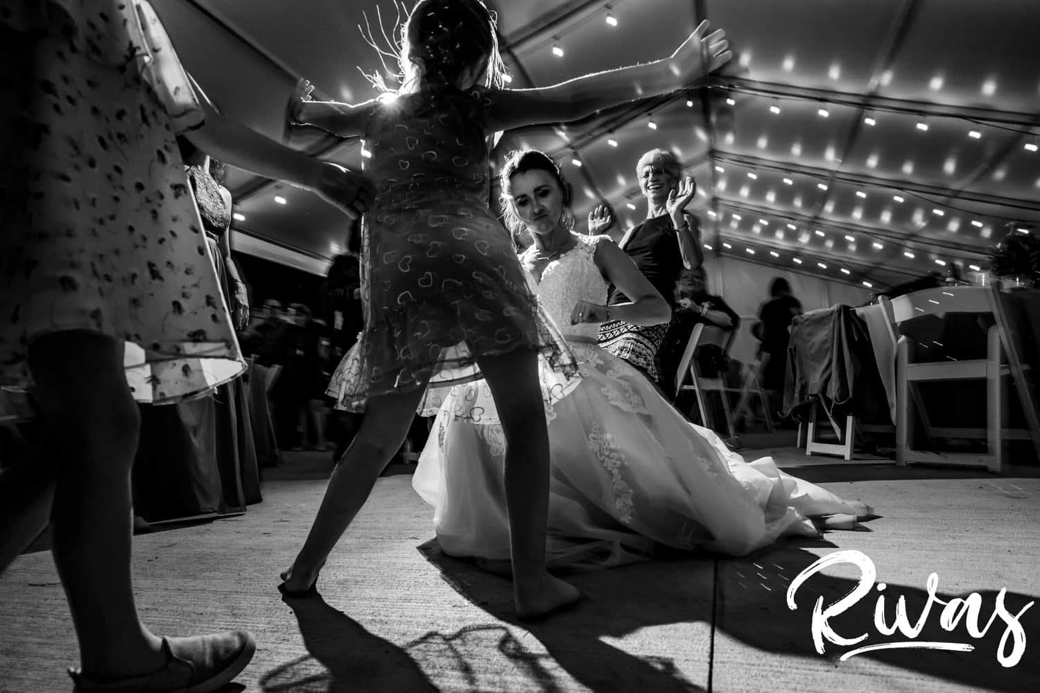 A candid black and white picture of a bride dancing with a small girl during her wedding reception at The Bowery in Kansas City. 