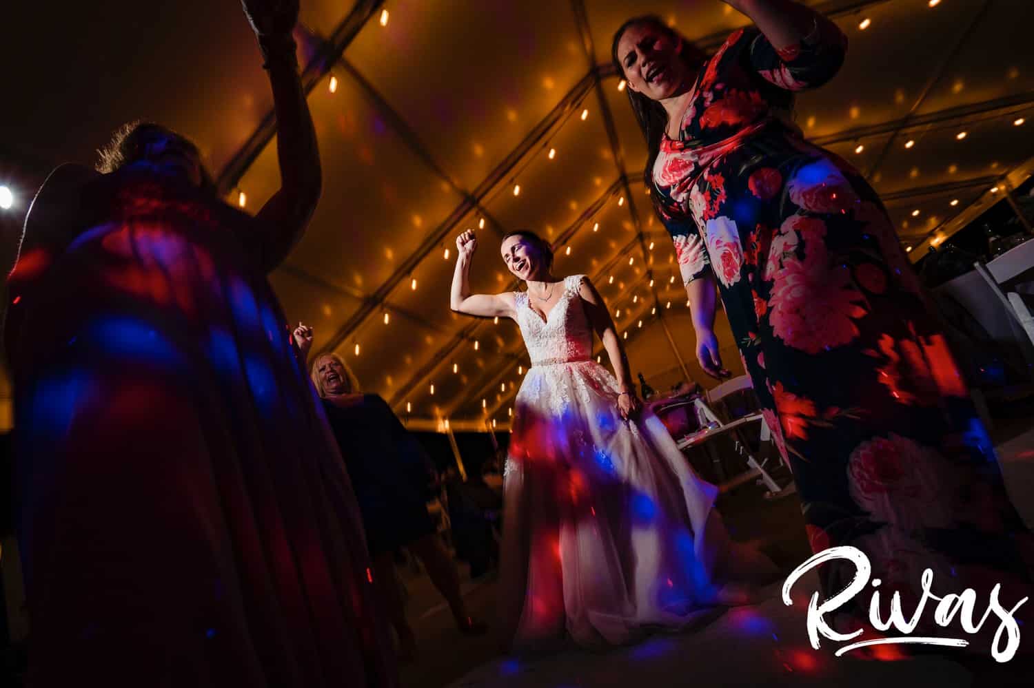A candid picture of a bride and group of friends dance together during a wedding reception at The Bowery in Spring Hill. 