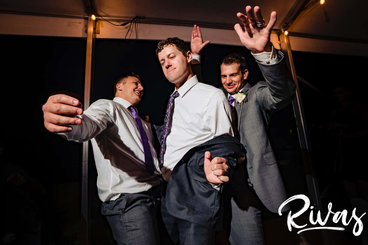 A candid picture of a groom and his groomsmen dancing together during a wedding reception at The Bowery in Kansas City. 