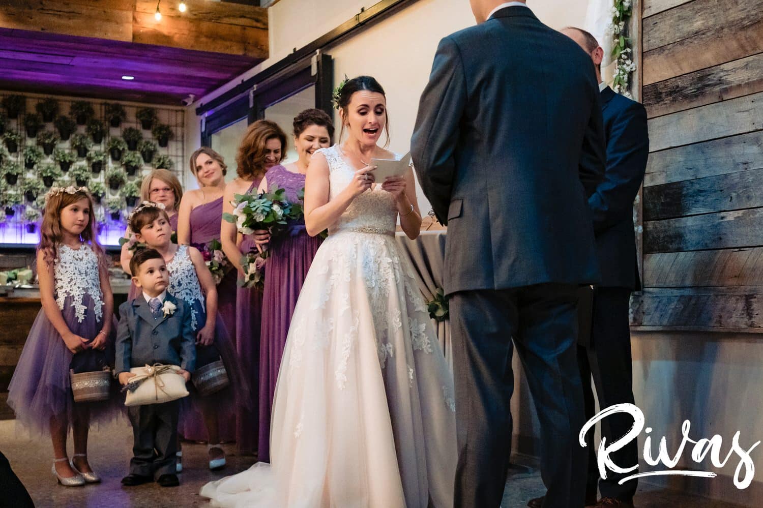 A candid, colorful picture of a bride reading her vows to her groom during their wedding ceremony at The Bowery in Kansas City. 
