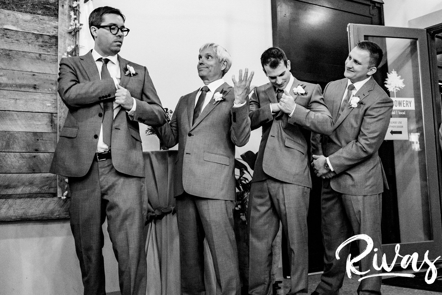 A candid, black and white picture of a group of groomsmen checking their pockets for the wedding bands during a ceremony at The Bowery in Kansas City. 