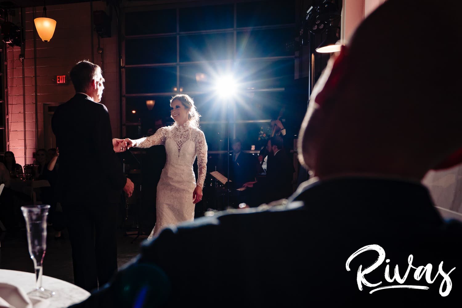 A candid picture taken over the groom's shoulder of a bride dancing with her father during their winter wedding reception in Kansas City. 