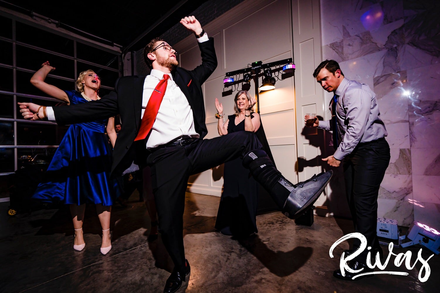 A colorful, candid picture of a group of people dancing during a winter wedding reception at The Station at 28 Event Space in Kansas City. 