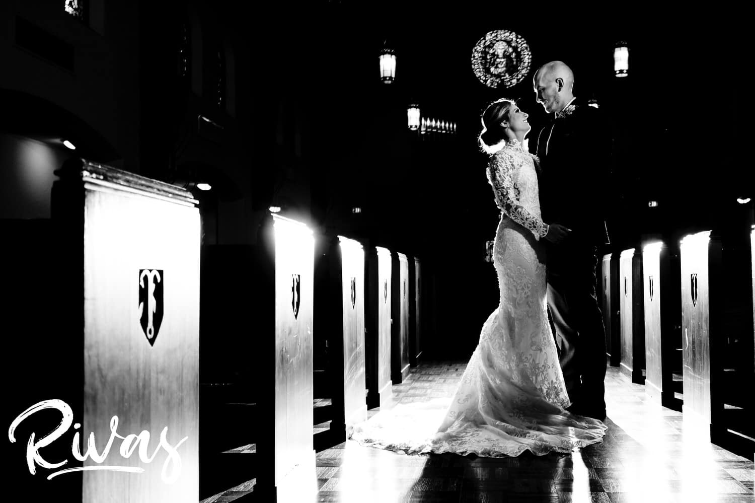A dramatic, black and white picture of a bride and groom standing in the center aisle of St. Andrew's Episcopal Church on their wedding day. 