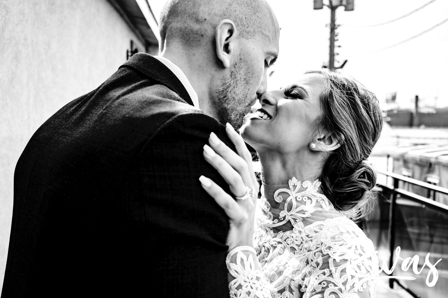 A candid, close-up black and white picture of a bride and groom leaning in to share a kiss on the morning of their sunny winter wedding in Kansas City. 