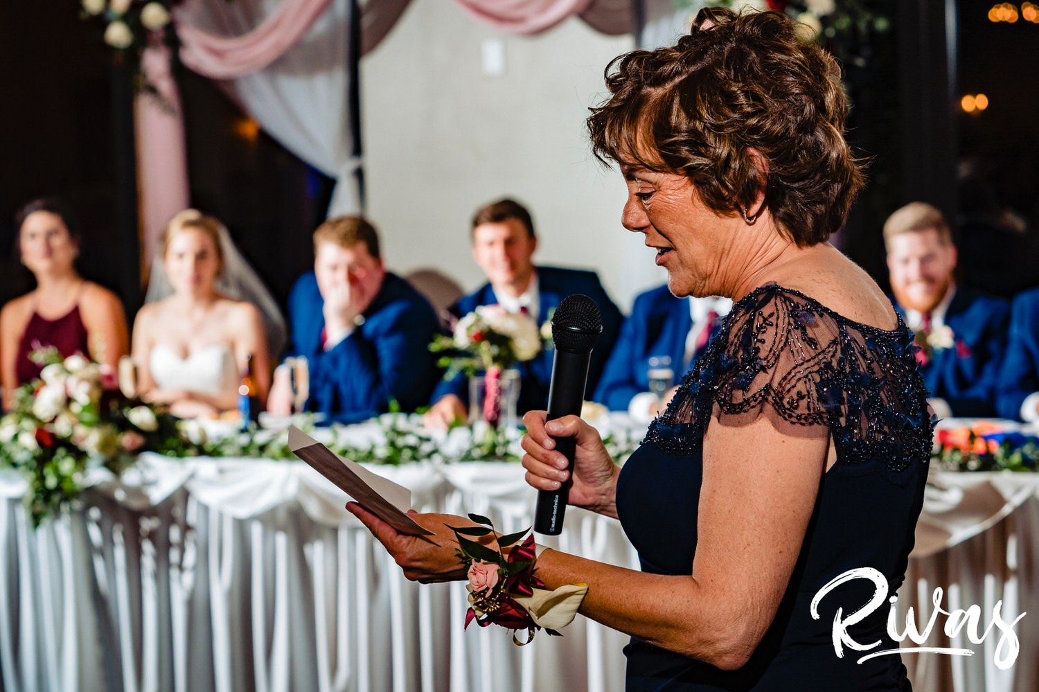 A candid picture taken over the shoulder of the mother of the bride as she toasts her daughter and new son-in-law during their fall wedding reception at Piazza Messina. 