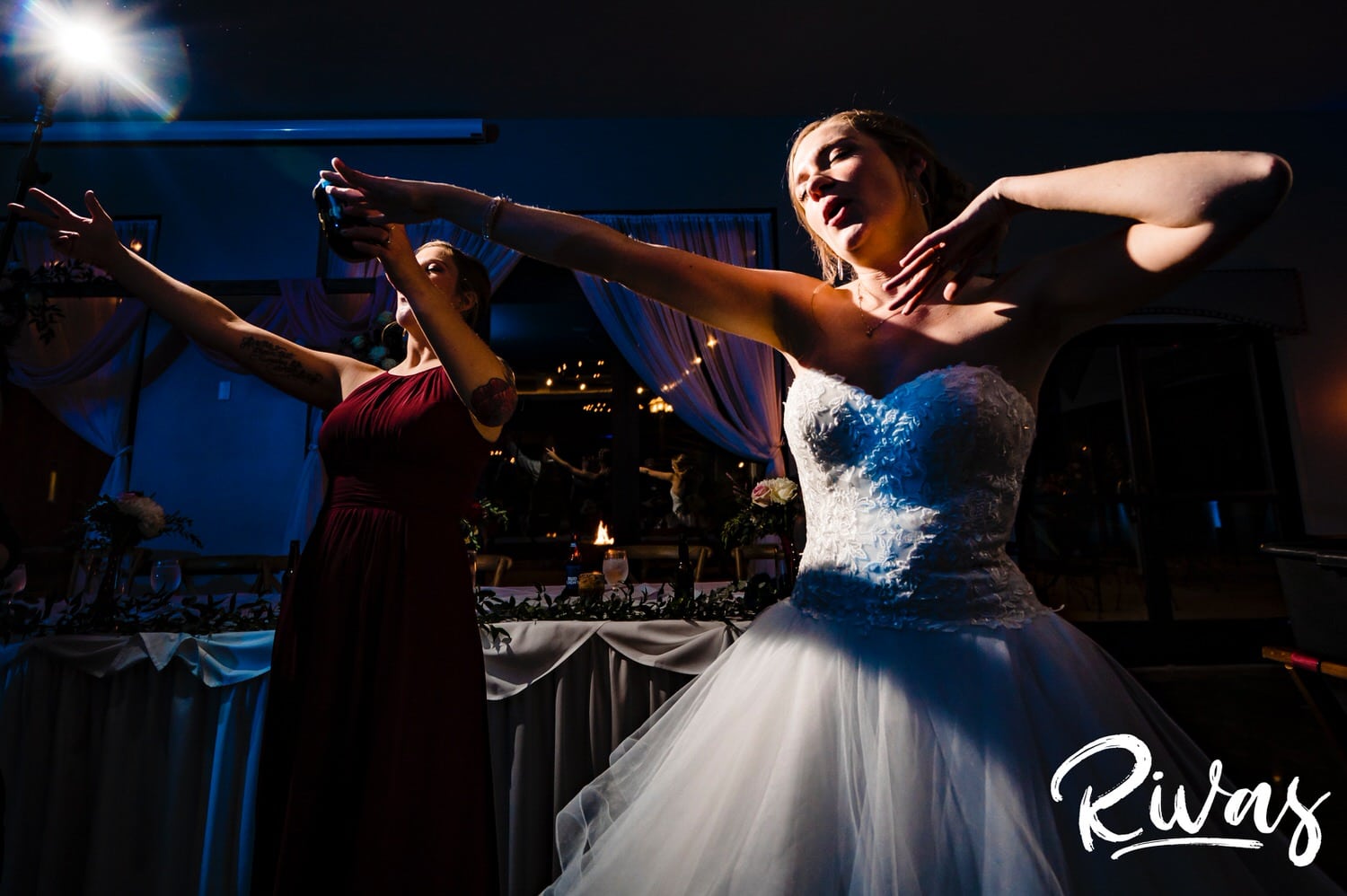 A candid picture of a bride with her ams stretched out wide in the middle of the dancefloor during her wedding reception at  Piazza Messina. 
