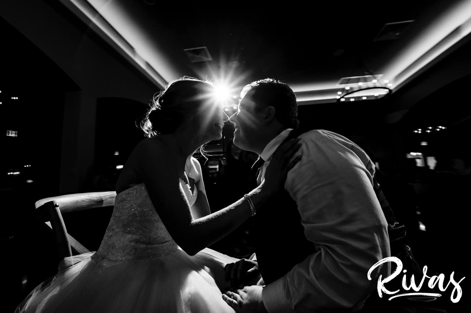 A black and white picture of a bride and groom leaning in to share a kiss during their Piazza Messina fall wedding reception. 