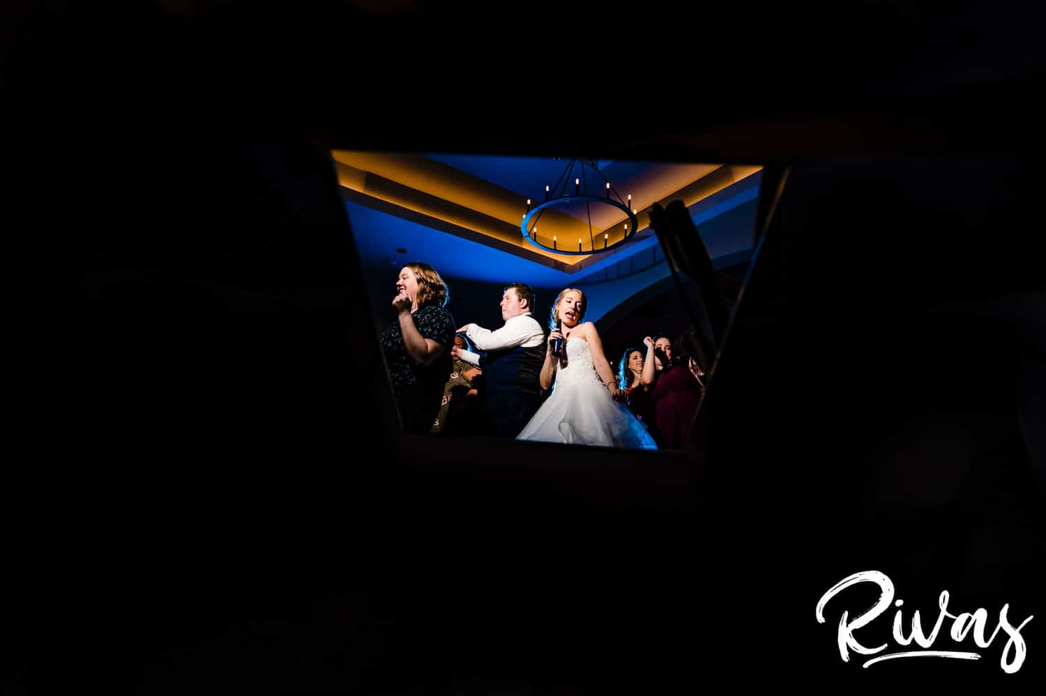 A colorful, candid picture of a bride and groom dancing wildly in the middle of the dance floor during their wedding reception at Piazza Messina. 