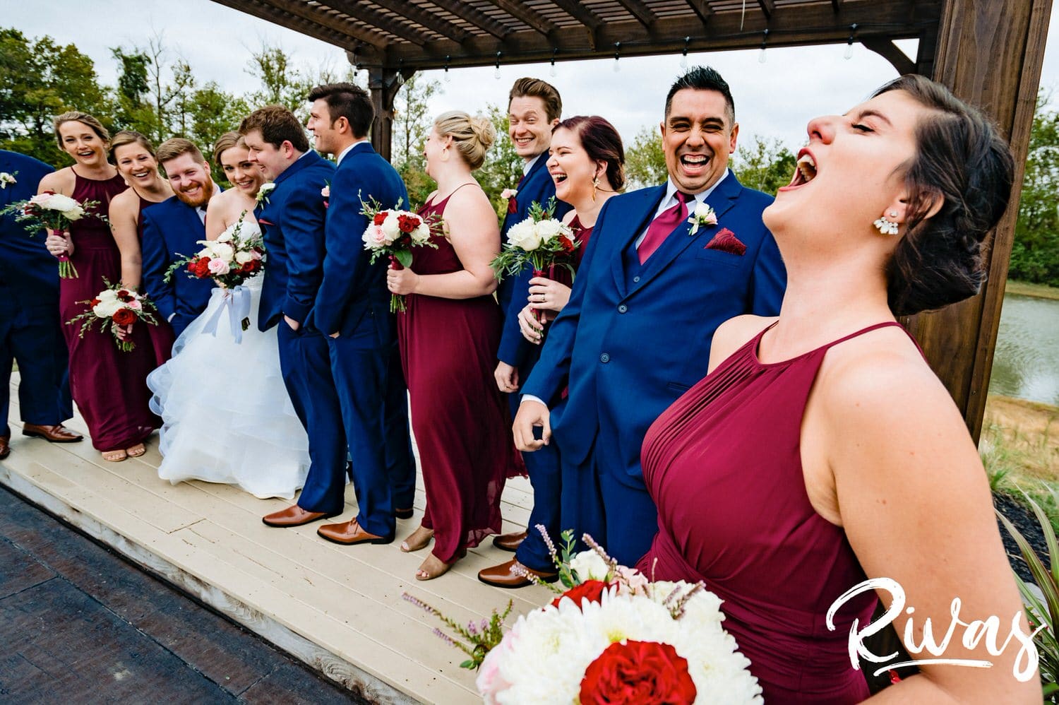 An up-close picture of a bridesmaid yelling something at the top of her lungs as the rest of the wedding party hysterically laughs with her on a fall wedding day at Piazza Messina. 