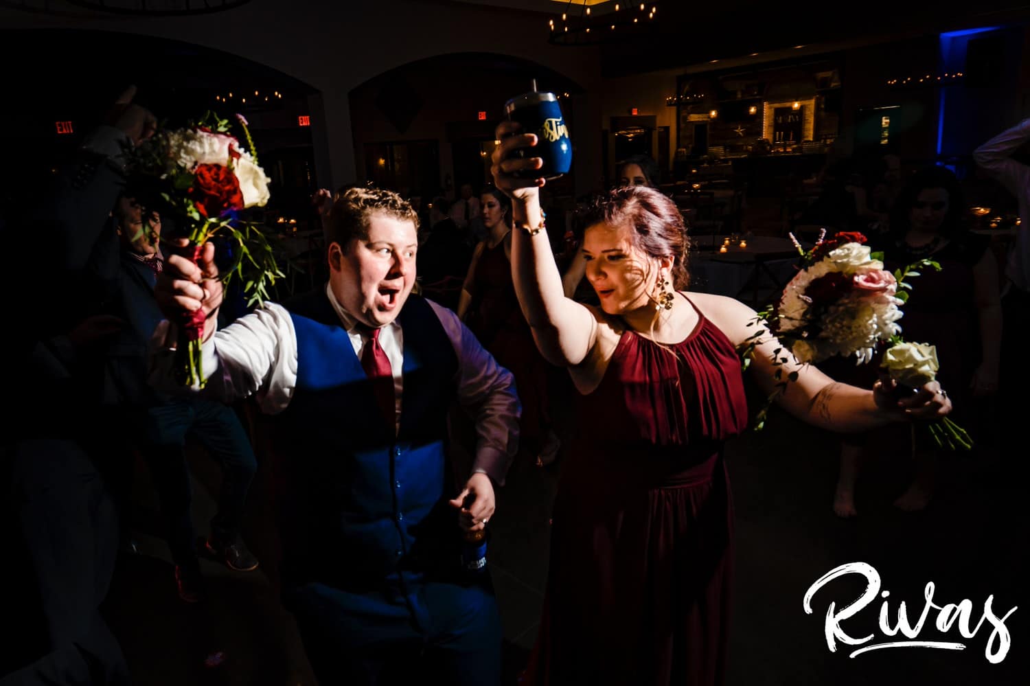 A candid picture of a groom and a bridesmaid dancing to "Macho Man" during a fall wedding reception at Piazza Messina. 