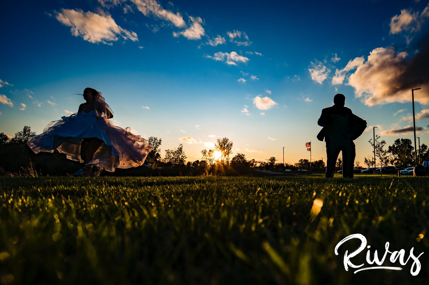 A colorful, semi-silhouetted picture of a bride and groom spinning in circles during sunset of their fall wedding day at Piazza Messina. 