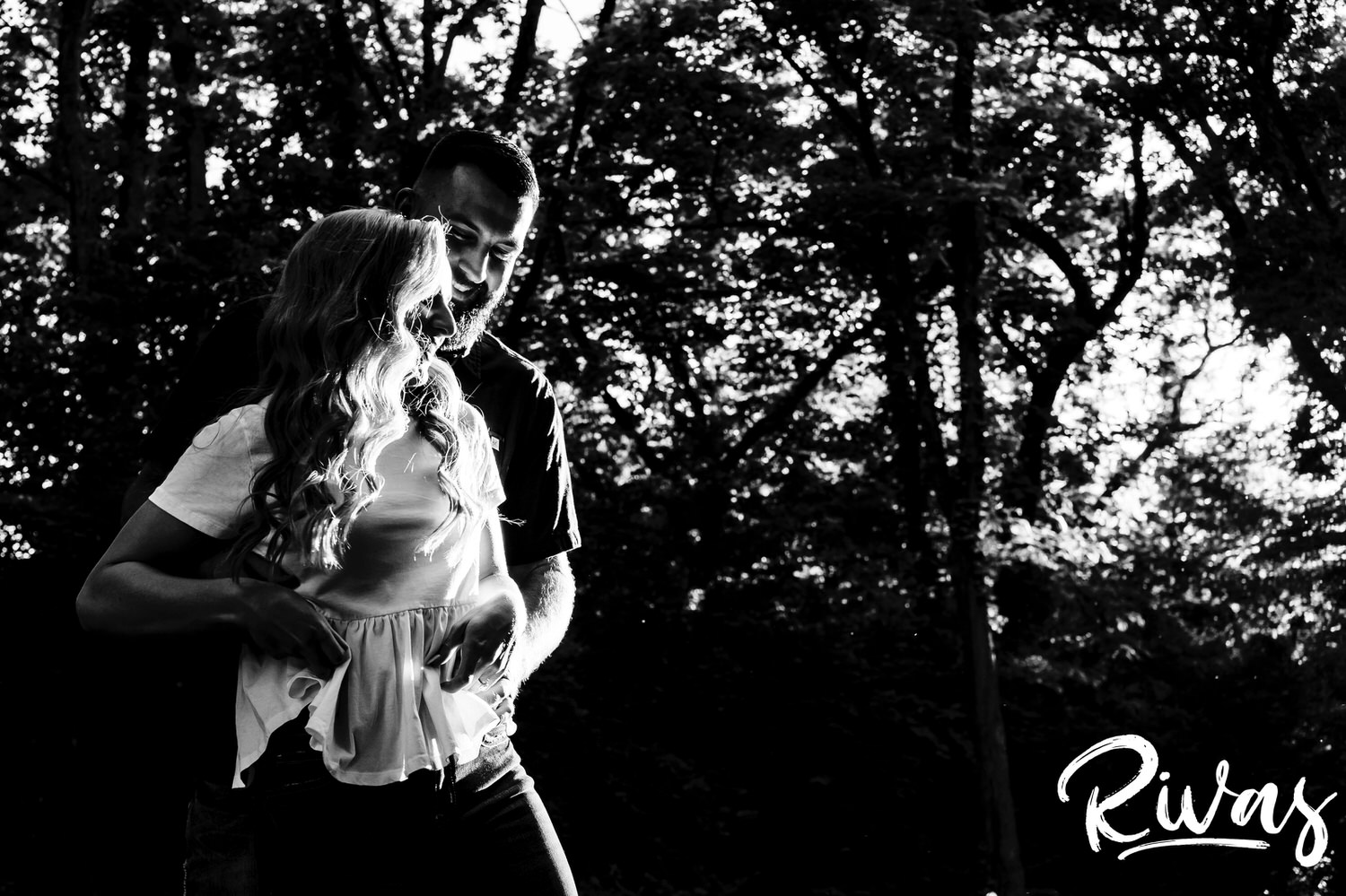 A candid, black and white picture of a couple sharing an intimate embrace during their summer engagement session in Kansas City. 