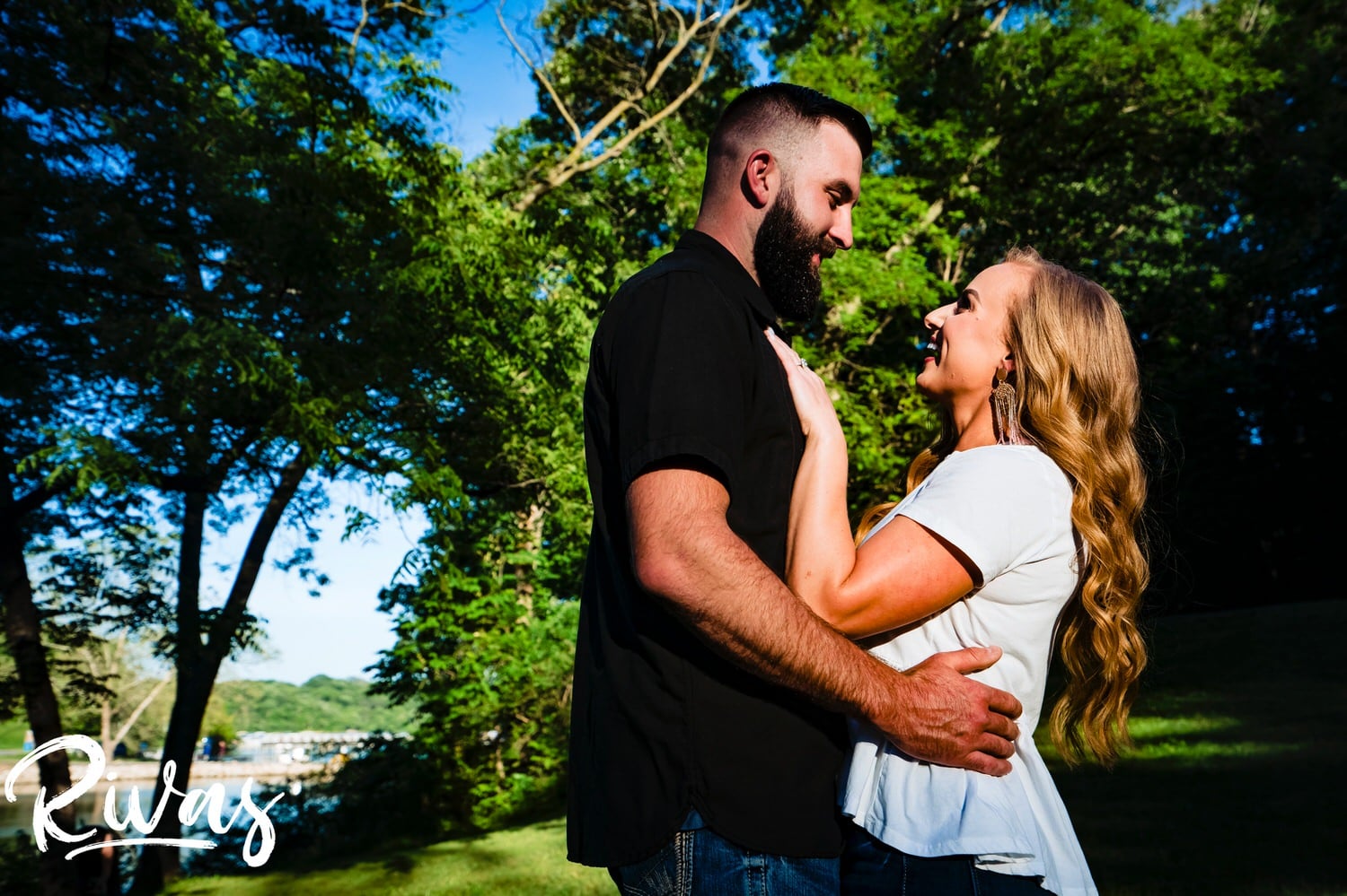 A vibrant portrait of an engaged couple sharing an embrace as they look at each other during an engagement session with their wedding photographer in Kansas City. 