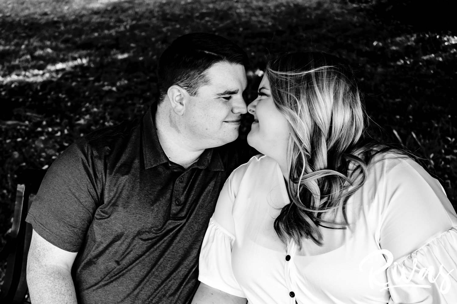 A close-up, black and white picture of an engaged couple leaning in to share a kiss during their engagement photography session. 