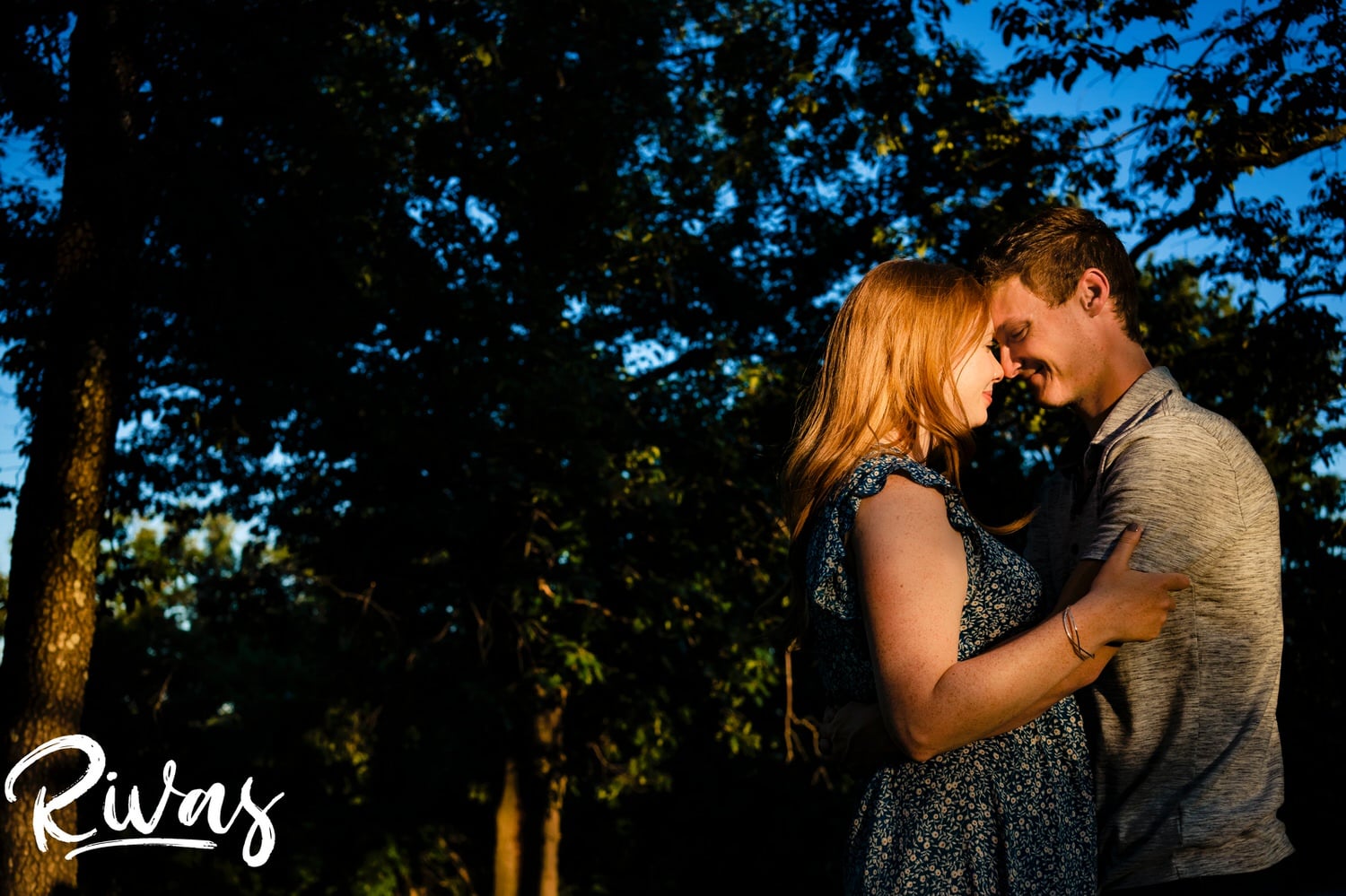 A vibrant, intimate picture of an engaged couple sharing an embrace, nose to nose during their KC summer engagement session at Wyandotte County Lake Park. 