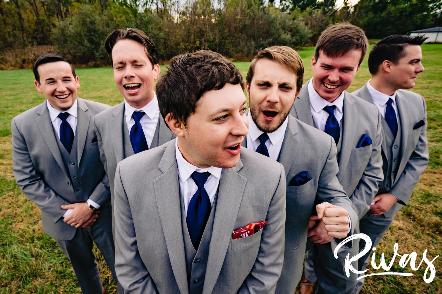 A colorful, candid picture of a groom and his groomsmen standing together laughing on the afternoon of his fall wedding at The Barns at Hamilton Station Vineyard. 