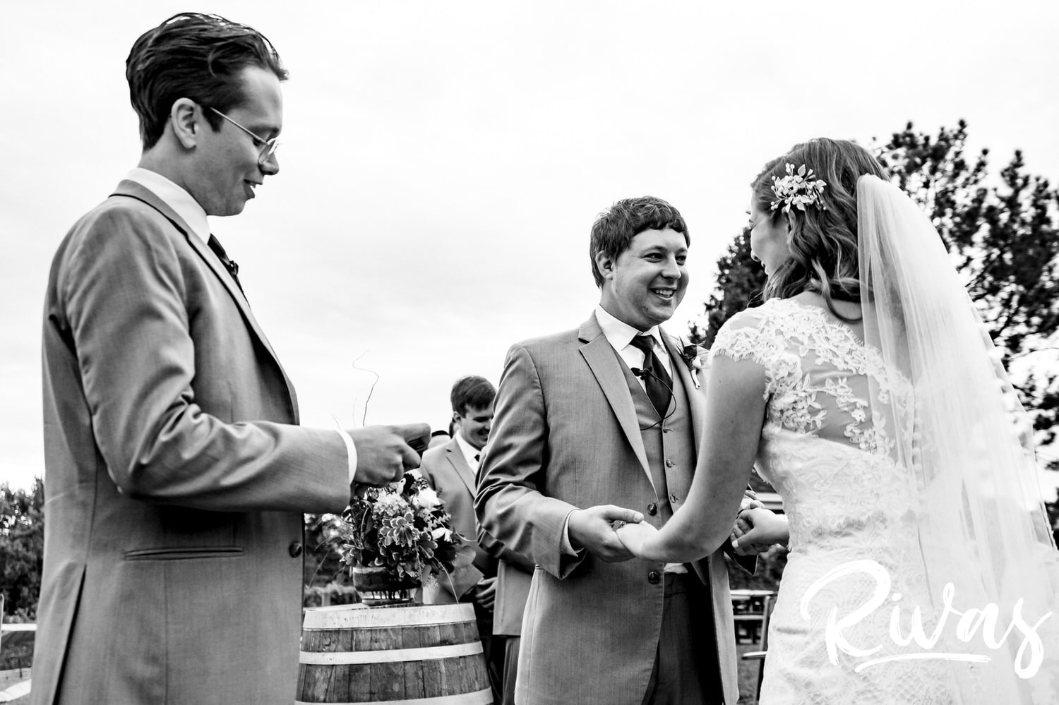 A candid black and white picture of a bride and groom holding hands during their fall wedding ceremony at The Barns at Hamilton Station Vineyard. 