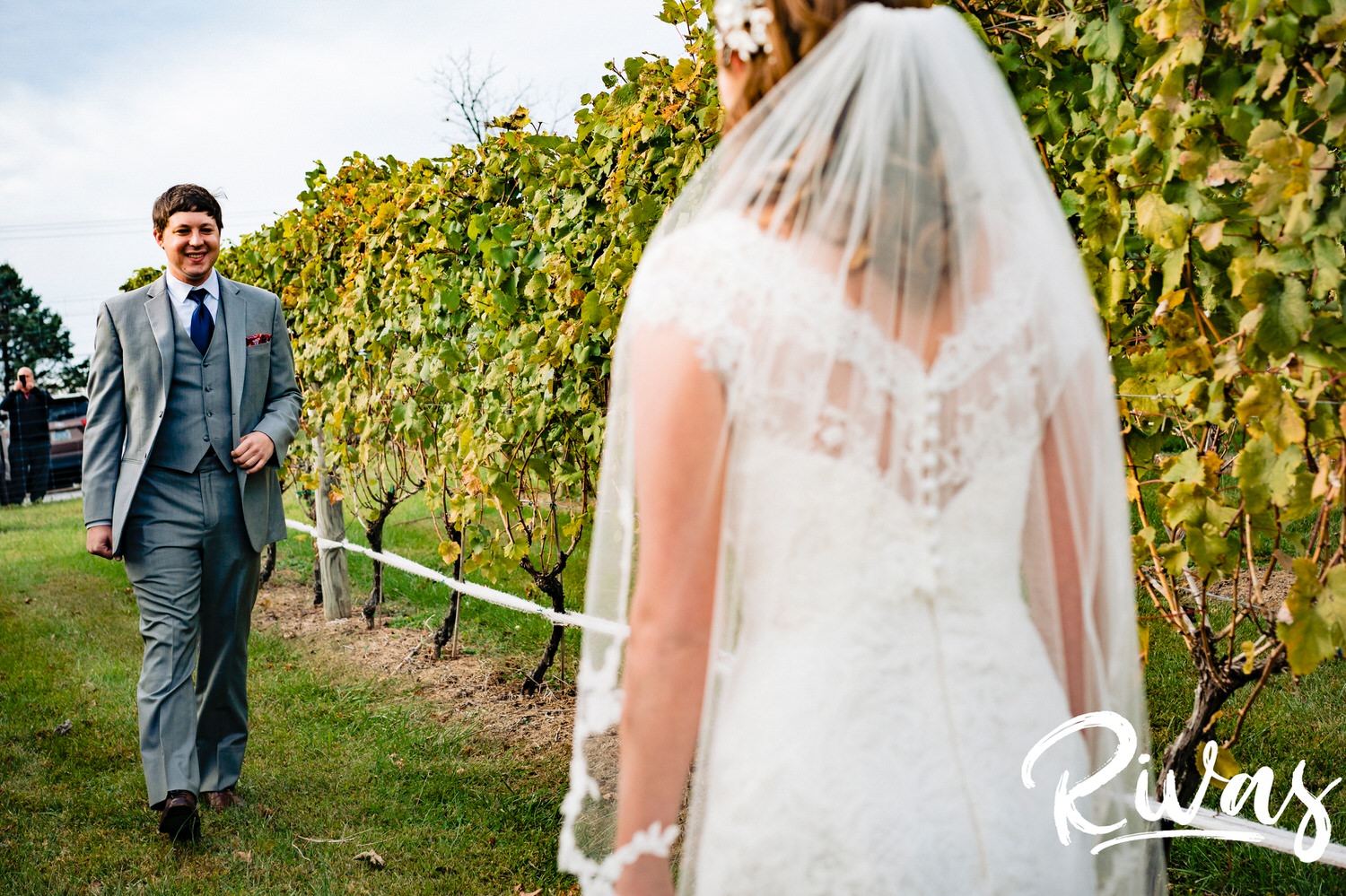 A colorful, candid picture of a groom walking towards his bride in the middle of a vineyard for their first look on the afternoon of their fall wedding day at The Barns at Hamilton Station Vineyard. 