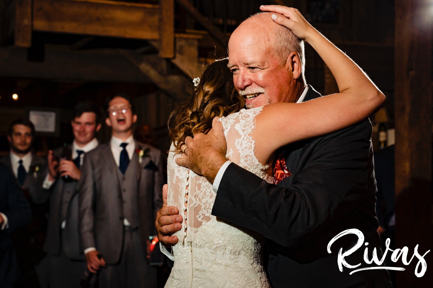 An intimate, colorful photo of a bride emotionally hugging her dad at the end of their father-daughter dance during her fall wedding reception. 